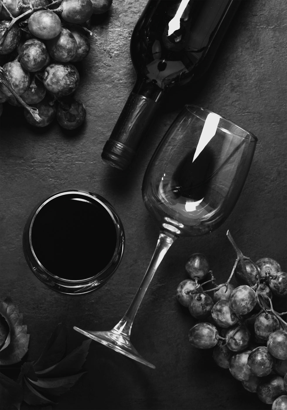 ein Glas Wein neben einer Weintraube