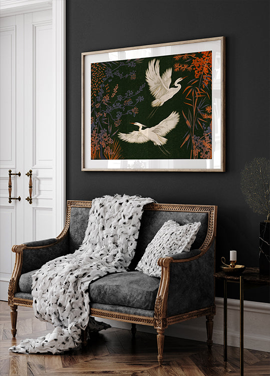 ein schwarz-weißes Sofa mit einer weißen Decke und zwei weißen Kissen, vor einer dunklen Wand, darüber ein gerahmtes Gemälde von zwei weißen Vögeln im Flug.